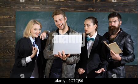 Group of different students using gadgets and reading book. Stock Photo