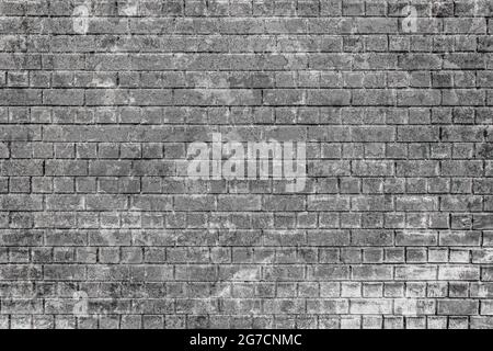 Old gray brick wall damaged and scuffed and peeled off as texture or background Stock Photo