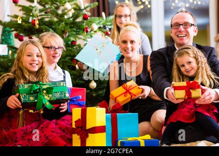 Family with lots of Christmas presents under tree Stock Photo