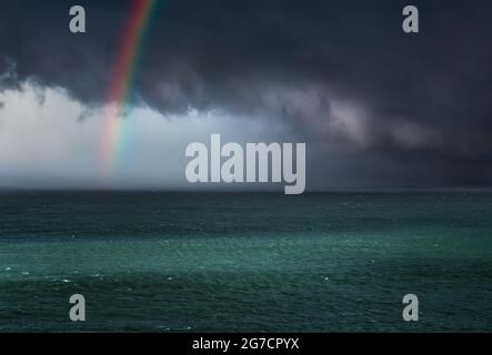 dramatic stormy clouds over the sea with a rainbow Stock Photo