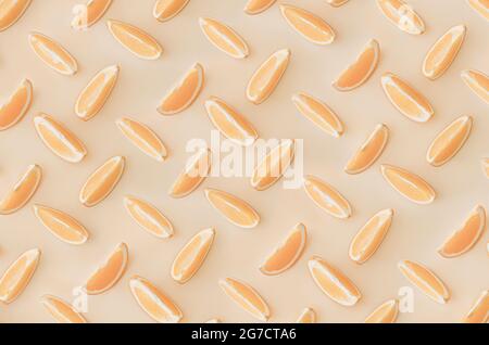 Fruit pattern of orange slices isolated on a light orange background. View from above. Stock Photo