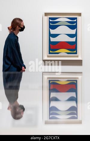 London, UK.  13 July 2021. A staff member poses with 'Coloured Gradation', 1939.  Preview of the first UK retrospective exhibition at Tate Modern of works by Sophie Taeuber-Arp (1889-1943), one of the foremost abstract artists and designers of the 1920s and 30s. Works from Taeuber-Arp’s accomplished career as a painter, architect, teacher, writer, and designer of textiles, marionettes and interiors is on 15 July – 17 October 2021.  Credit: Stephen Chung / Alamy Live News