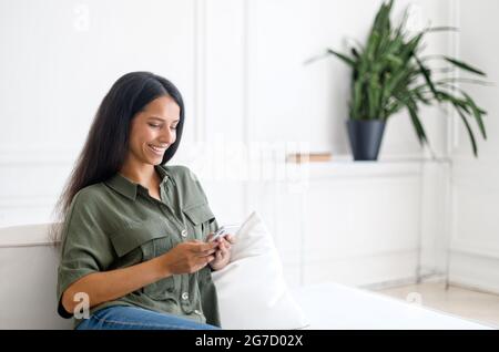 Smiling Indian Woman Scrolling Social Networks On Smartphone While ...