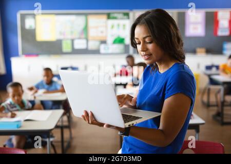 African american female teacher using laptop in the class at school Stock Photo