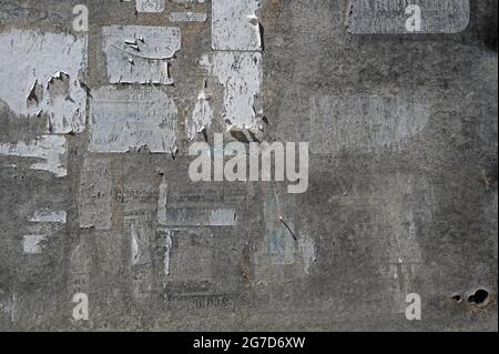 Surface of an old weathered bulletin board with remnants of torn paper ads, abstract grunge background texture, copy space Stock Photo