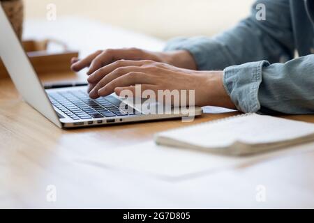 Close up view male hands writing on laptop Stock Photo
