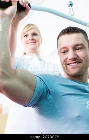 Patient at the physiotherapy doing physical exercises with therapist in sport rehabilitation Stock Photo
