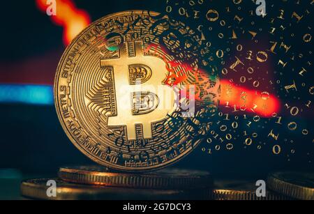 Crypto currency golden coin. Gold bitcoin falling apart. Concept of a cryptocurrency market crisis and defocused chart background. Stock Photo