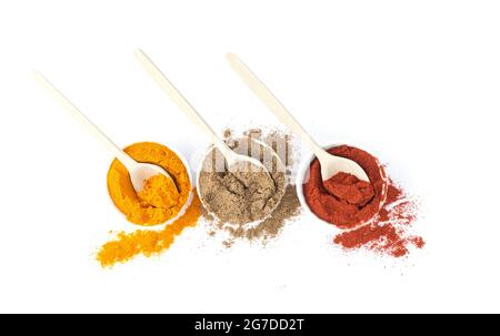 Group of indian spices and herbs with wooden spoons in bowls isolated on white background with top view Stock Photo