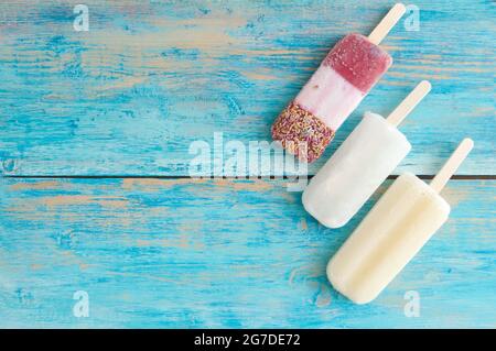 Frozen assorted ice lollies on a wooden background Stock Photo