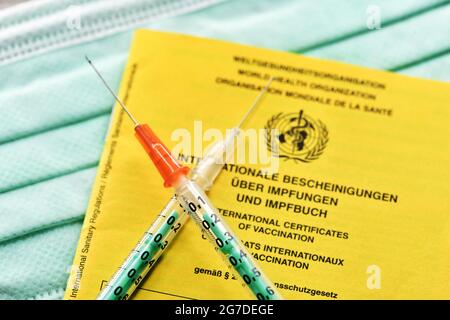 Crossed syringes on vaccination card, mix-and-match vaccination Stock Photo