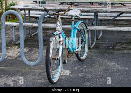 NEW ORLEANS, LA, USA - JULY 6, 2021: Old beat up bicycle locked to rack Stock Photo