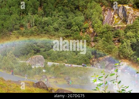 Norway, Olden - August 1, 2018: People at pathway to Briksdal or Briksdalsbreen glacier with green mountains, snow and waterfall Stock Photo