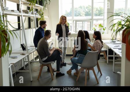 Mature presenter giving consultation to team of managers Stock Photo