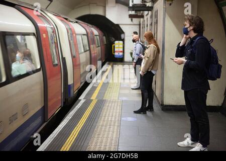 London, UK, 13 July 2021: Communters and tourists on the London Underground mostly wear face masks. London Mayor Sadiq Khan is said to support Transport for London in making face masks a condition of carriage even after the government removes the legal requirement from19 July onwards.  Anna Watson/Alamy Live News Stock Photo