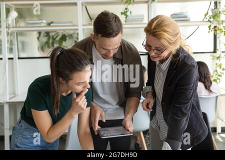 Team of focused office employees talking, discussing project Stock Photo