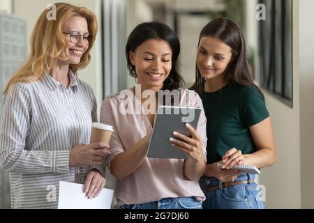 Mixed race leader showing virtual presentation on tablet to employees Stock Photo