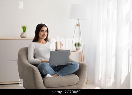 Young beautiful smiling casual woman enjoying cup of coffee Stock Photo