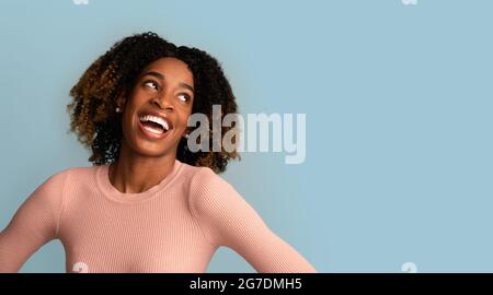 Great Offer. Cheerful African Lady Looking Aside At Copy Space With Excitement Stock Photo