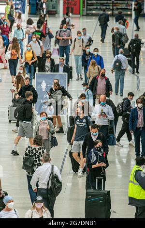 WATERLOO LONDON  13 July 2021.  Crowds of travelers at  Waterloo station  a day after Prime Minister’s Boris Johnson delivered  a TV press conference at Downing Street on the government’s decision to unlocking  Covid-19 restrictions on 19 July 2021  known as Freedom Day. The government has ssuing guidance  on wearing face masks, social distancing  and working from home where it will p longer be mandatoary to wear a facemask and only a personal choice. Credit amer ghazzal/Alamy Live News Stock Photo