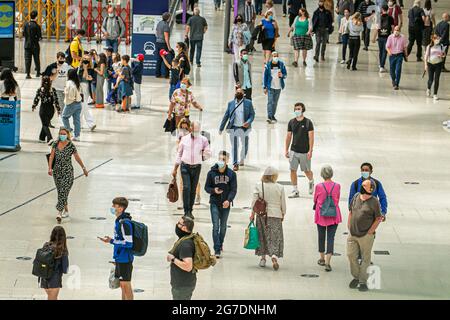 WATERLOO LONDON  13 July 2021.  Travelers at  Waterloo station  wearing masks  a day after Prime Minister’s Boris Johnson delivered  a TV press conference at Downing Street on the government’s decision to unlocking  Covid-19 restrictions on 19 July 2021  known as Freedom Day. The government has ssuing guidance  on wearing face masks, social distancing  and working from home where it will p longer be mandatoary to wear a facemask and only a personal choice. Credit amer ghazzal/Alamy Live News Stock Photo