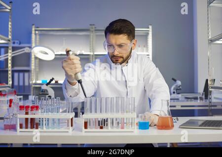 Young scientist working with samples in a pharma or biotech scientific laboratory Stock Photo