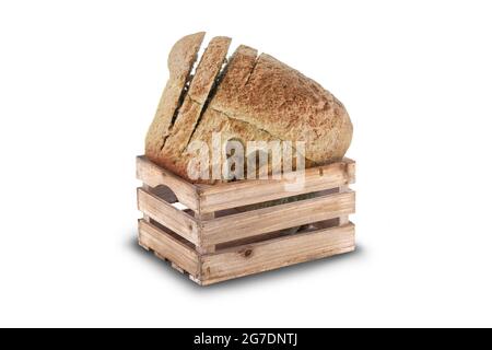 Love fresh bread concept in a wooden crate isolated on white background. Love heart cutout into crusty wholemeal loaf with slices partly cut Stock Photo