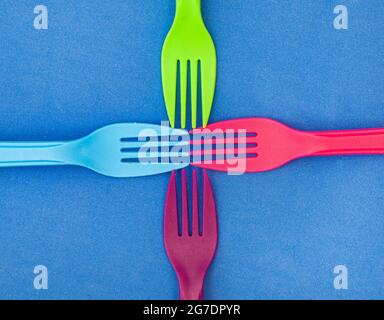 brightly colored plastic forks on colorful background with copy space Stock Photo