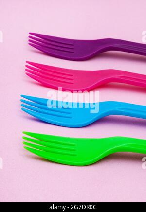 brightly colored plastic forks on colorful background with copy space Stock Photo