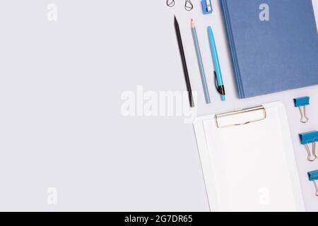 Layout of office stationery on a blue background. Neat workspace with place for text. Stock Photo