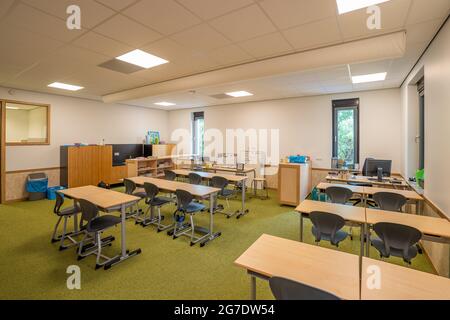 OUD BEIJERLAND, NETHERLANDS - Jun 21, 2021: A classroom for primary school students with tables and chairs neatly lined up Stock Photo