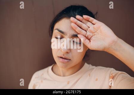 Stressed woman suffering of heatstroke refreshing with cold water outside. Weather abnormal heat concept Stock Photo