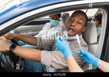 African American Family Getting Tested For Covid-19 Sitting In Car Stock Photo