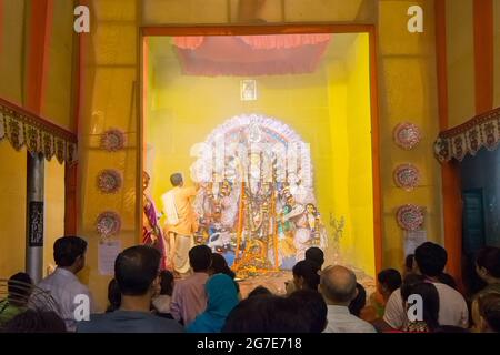 KOLKATA , INDIA - OCTOBER 18, 2015 : Priest praying to Goddess Durga, shot at colored light. It is the biggest religious festival of Hinduism and Beng Stock Photo