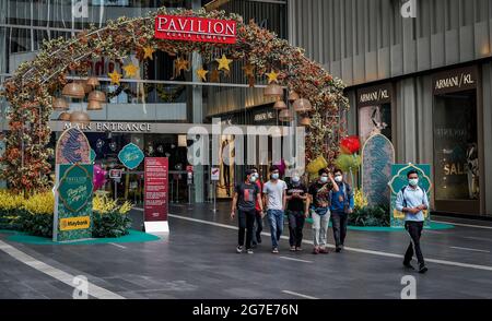 People wearing face masks seen walking from a closed shopping mall. Stock Photo