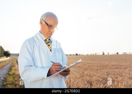 Agricultural scientist doing research in green biotech entering data on his tablet computer Stock Photo