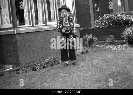 1930s, historical, a young boy standing in a front garden outside a house, dressed in a cowboy costume, Mirfield, Yorkshire, England, UK. Stock Photo