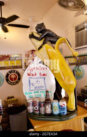 Monkey riding a banana sculpture at Bien - Caribbean & Latin food restaurant in Key West, Florida, FL, USA Stock Photo