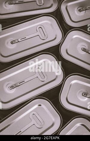 Monochrome twist-key tin opener / can-opener on an ASDA luncheon meat tinned product. Concept for food preservation, opening a can of worms. Stock Photo