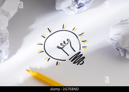 Bright Idea Concept. Hand Drawn Light Bulb On Paper and crumpled paper around. Creative process concept Stock Photo