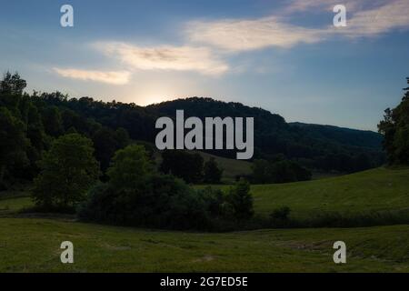 Sun slides behind the hills late summer evening in North Eastern Tennessee Stock Photo