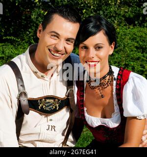 Couple- man and woman - in traditional Bavarian dress, Lederhosen and Dirndl Stock Photo