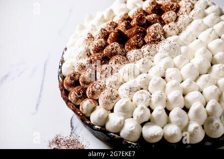 Homemade gluten free tiramisu traditional italian dessert sprinkled with cocoa powder over white marble table Stock Photo