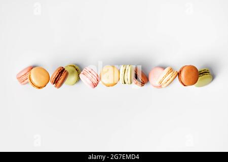 Vintage pastel colored French macaroons or macarons in motion falling on grey background. Macaron Sweets Stock Photo