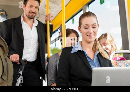 Passengers in a bus - a commuter, a father with a stroller, a man Stock Photo