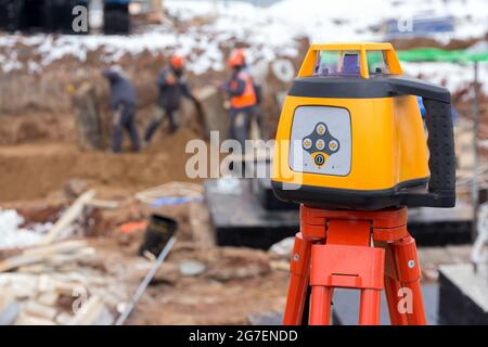 Laser rangefinder at a construction site. Measuring tool at a construction site. Accurate construction site measurement equipment Stock Photo