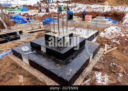 Waterproofing technology at a construction site. Columnar foundation covered with black waterproofing compound Stock Photo