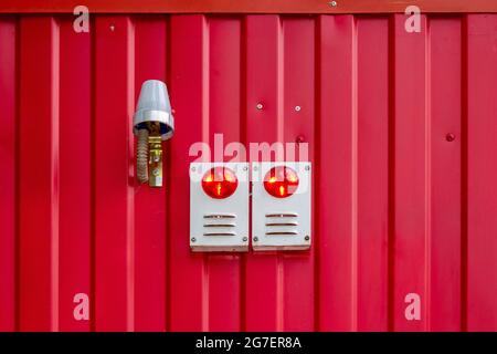 Sound and light alarm system block on the red wall of the building. Stock Photo