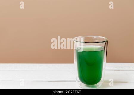 Green chlorophyll drink in a glass on white table with copy space Stock Photo