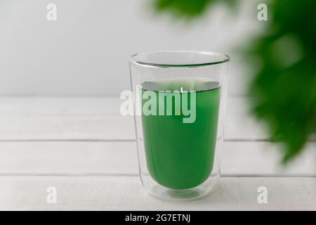 New superfood trend liquid chlorophyll in a cup with water on light background, copy space, selective focus Stock Photo